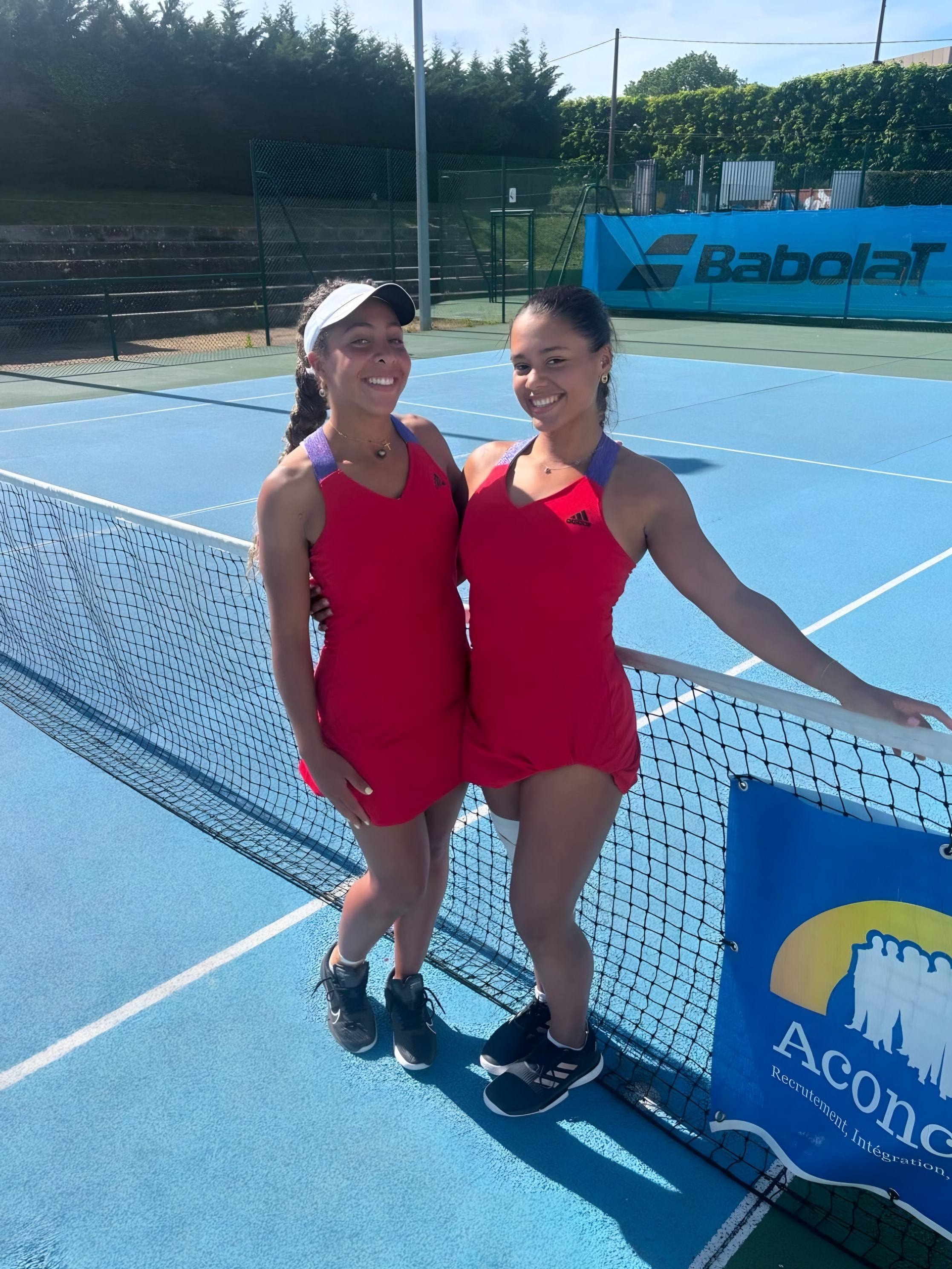 Sophia et Jade au filet devant une bâche Babolat