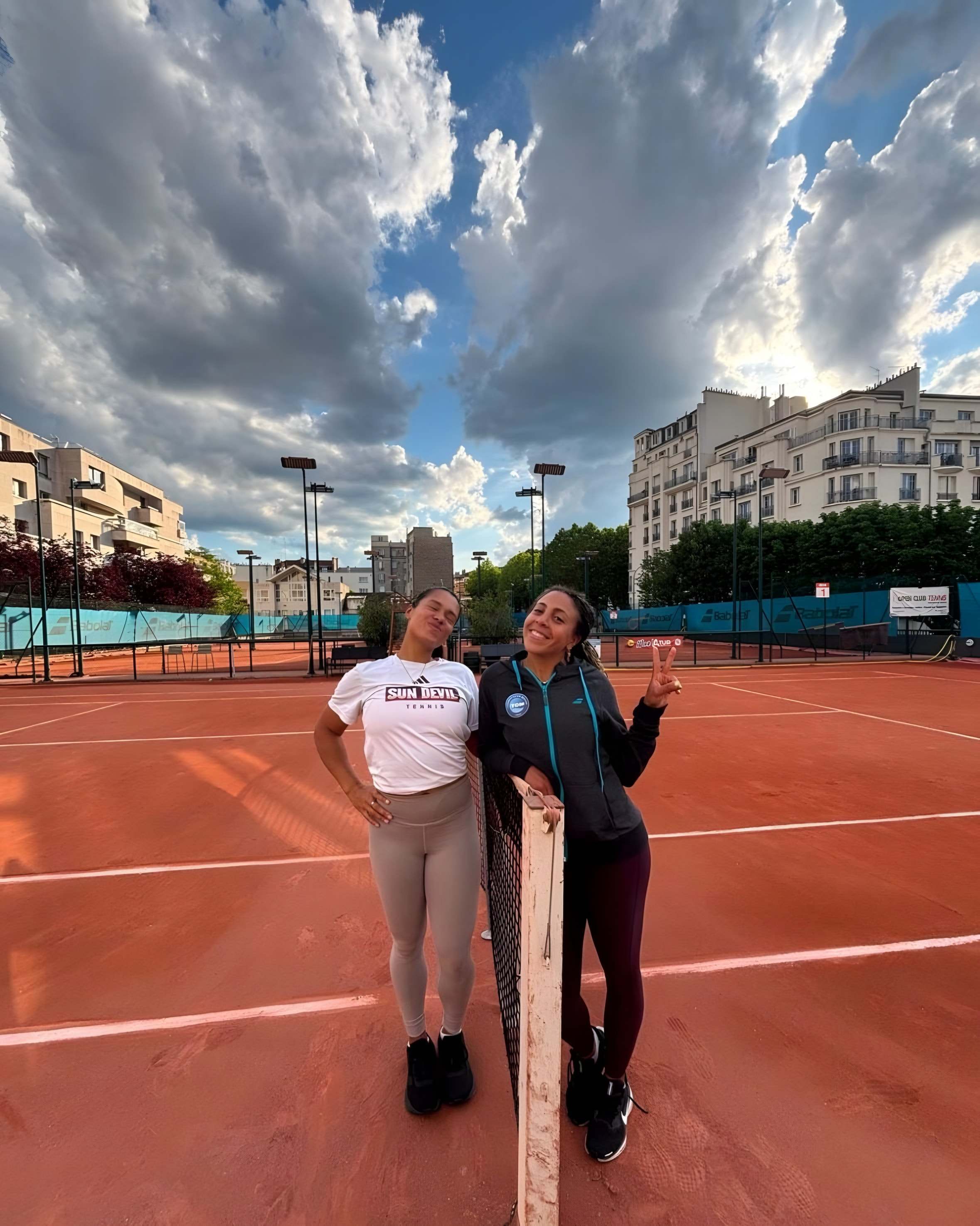 Sophia et Jade côte à côte sur un court en terre battue parisien, ciel de traîne