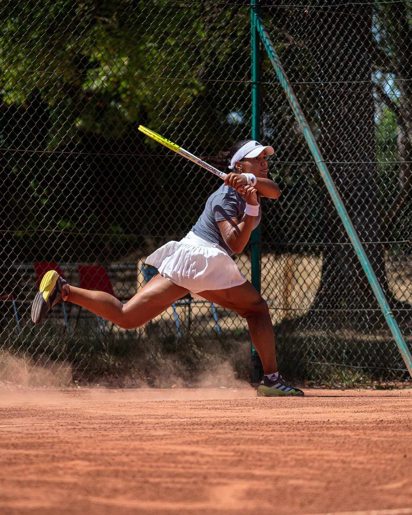Jade en glissade sur la terre battue, coup droit en pleine extension